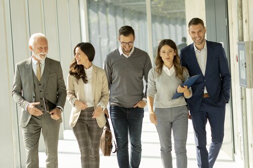 Business professionals talking while walking in office corridor